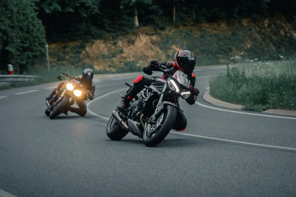 Motocicliști conducând relaxat pe un drum sinuos, în stare de flow